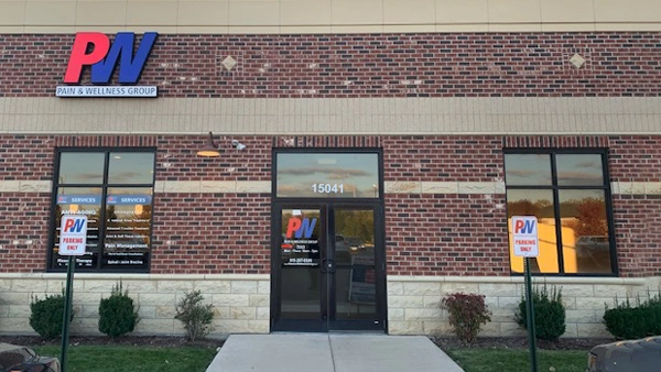 Pain and Wellness Group building, featuring two windows, a centered door, and the logo.